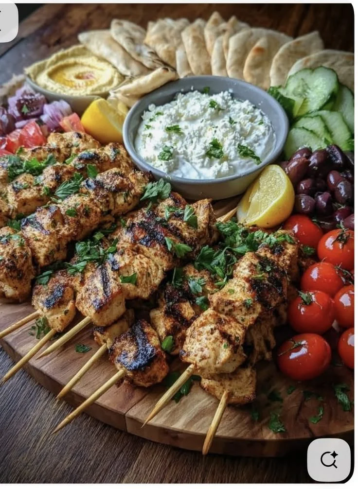 Grilled chicken skewers served alongside sides and dips for a delicious meal