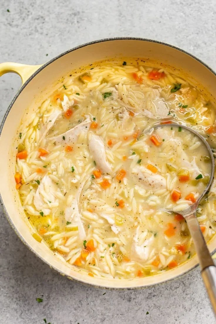 Bowl of Greek lemon chicken orzo soup garnished with parsley